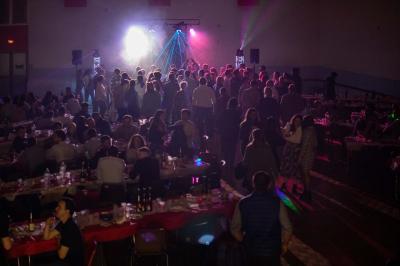 Salle en bois avec charpente apparente, équipée de matériel de sonorisation et d'éclairage pour un événement.