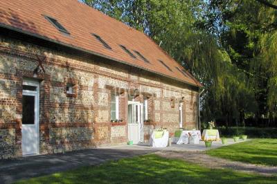 Un jardin verdoyant avec des arbres, de l'herbe fraîchement tondue, un banc en pierre et une clôture en arrière-plan.