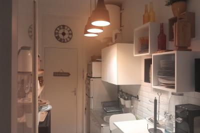 Terrasse en pierre avec mobilier de jardin, entourée de plantes en pots, donnant sur des immeubles en briques.