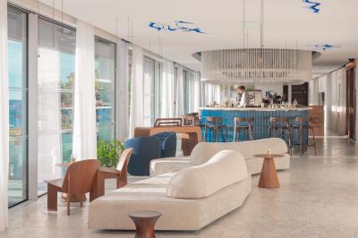 Table dressée pour deux avec vue sur un port de plaisance, des voiliers et la mer sous un ciel dégagé.