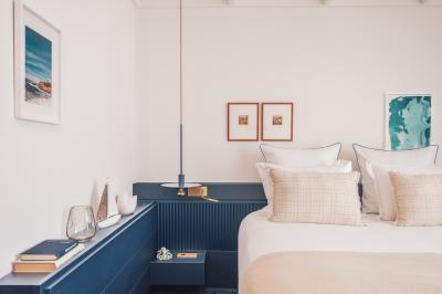 Table dressée pour deux avec vue sur un port de plaisance, des voiliers et la mer sous un ciel dégagé.