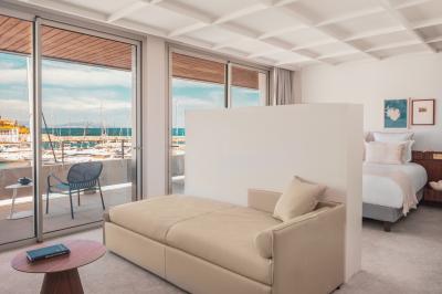 Table dressée pour deux avec vue sur un port de plaisance, des voiliers et la mer sous un ciel dégagé.