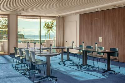 Table dressée pour deux avec vue sur un port de plaisance, des voiliers et la mer sous un ciel dégagé.
