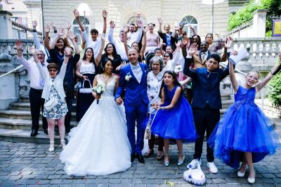 Un couple danse ensemble dans une salle décorée de ballons, entouré de quelques invités en arrière-plan.