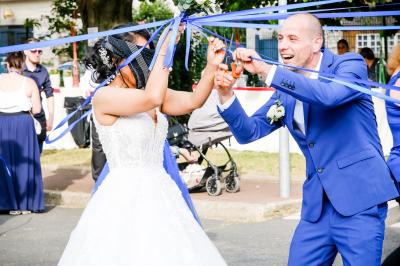 Un couple danse ensemble dans une salle décorée de ballons, entouré de quelques invités en arrière-plan.