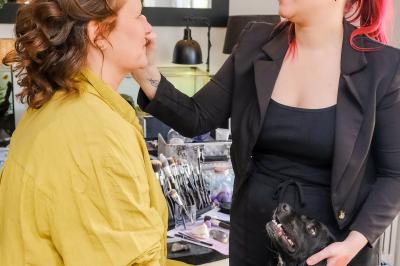 Un couple danse ensemble dans une salle décorée de ballons, entouré de quelques invités en arrière-plan.