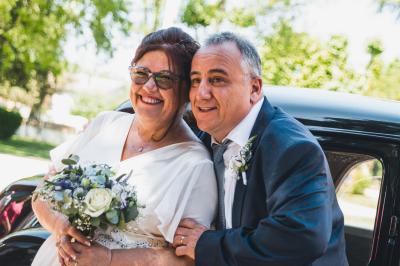 Un couple danse ensemble dans une salle décorée de ballons, entouré de quelques invités en arrière-plan.
