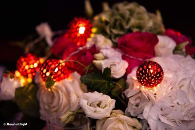 Un couple danse ensemble dans une salle décorée de ballons, entouré de quelques invités en arrière-plan.