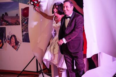 Un couple danse ensemble dans une salle décorée de ballons, entouré de quelques invités en arrière-plan.