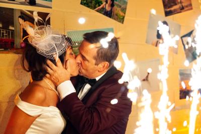 Un couple danse ensemble dans une salle décorée de ballons, entouré de quelques invités en arrière-plan.