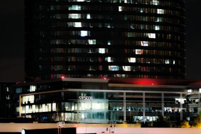 Vue aérienne d'une place animée avec des stands, une statue centrale et des bâtiments historiques environnants.