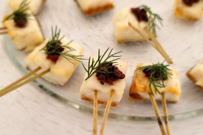 Plateau de pâtisseries garnies de crème blanche, nappées de chocolat et parsemées d'amandes effilées grillées.