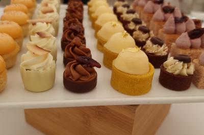 Plateau de pâtisseries garnies de crème blanche, nappées de chocolat et parsemées d'amandes effilées grillées.