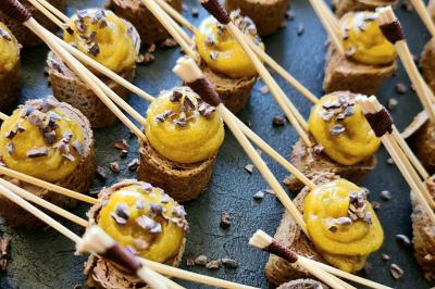 Plateau de pâtisseries garnies de crème blanche, nappées de chocolat et parsemées d'amandes effilées grillées.