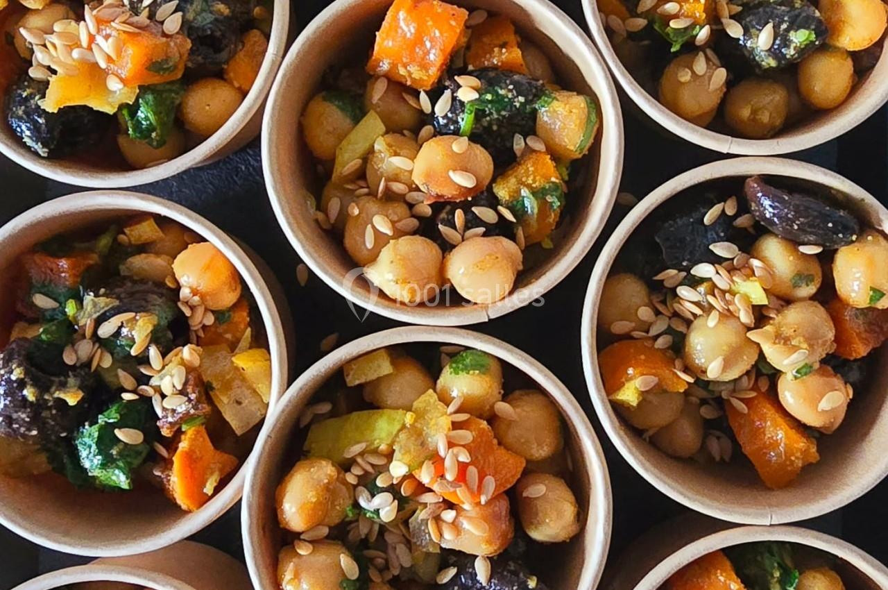 Coupes individuelles remplies de salade de pois chiches, légumes colorés et graines de sésame.