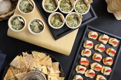 Plateau de pâtisseries garnies de crème blanche, nappées de chocolat et parsemées d'amandes effilées grillées.
