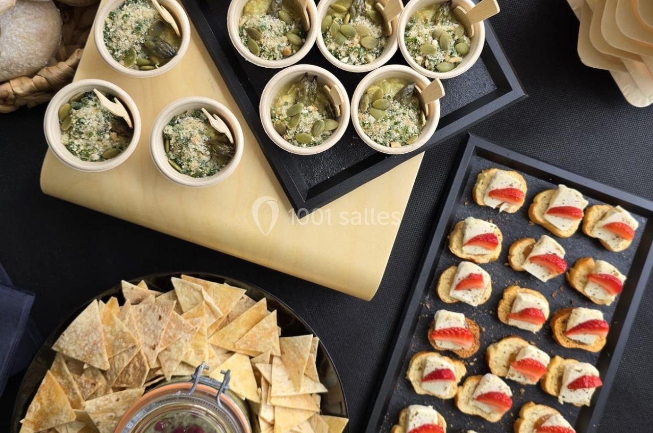 Buffet de bouchées apéritives comprenant verrines, toasts, chips avec sauce, pains et mini-burgers.