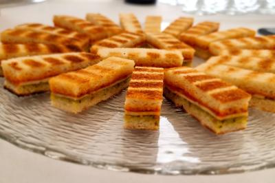 Plateau de canapés garnis de crevettes et mousse noire, disposés sur une table devant un sapin illuminé.