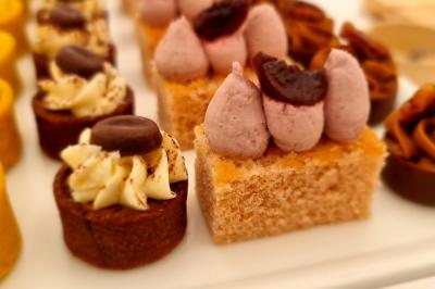 Plateau de canapés garnis de crevettes et mousse noire, disposés sur une table devant un sapin illuminé.