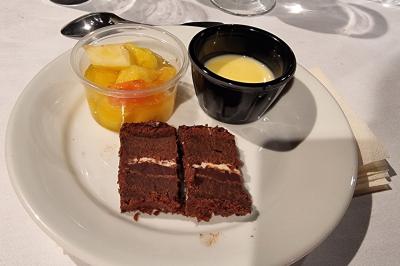 Plateau de canapés garnis de crevettes et mousse noire, disposés sur une table devant un sapin illuminé.