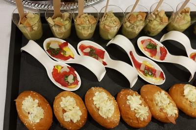 Plateau de canapés garnis de crevettes et mousse noire, disposés sur une table devant un sapin illuminé.