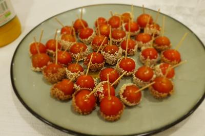Plateau de canapés garnis de crevettes et mousse noire, disposés sur une table devant un sapin illuminé.