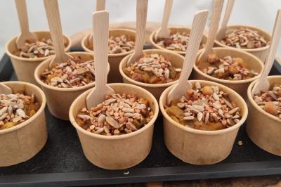 Plateau de canapés garnis de crevettes et mousse noire, disposés sur une table devant un sapin illuminé.