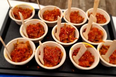 Plateau de canapés garnis de crevettes et mousse noire, disposés sur une table devant un sapin illuminé.