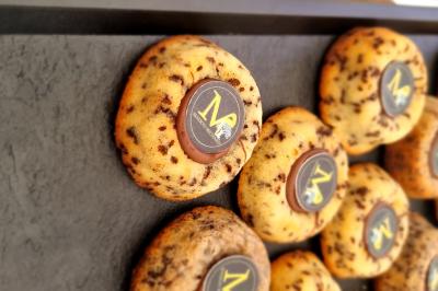 Plateau de canapés garnis de crevettes et mousse noire, disposés sur une table devant un sapin illuminé.