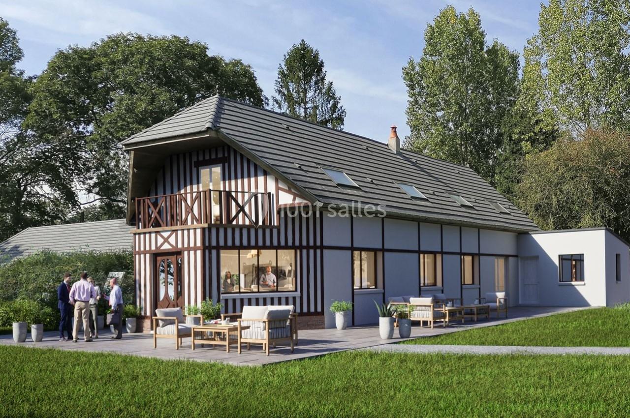 Maison à colombages moderne avec terrasse aménagée, entourée de pelouse et d'arbres, avec un groupe de personnes discutant.