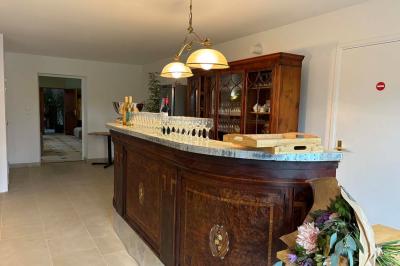 Salle de bain moderne avec douche à paroi vitrée, lavabo rond sur meuble en bois et miroir encadré en rotin.