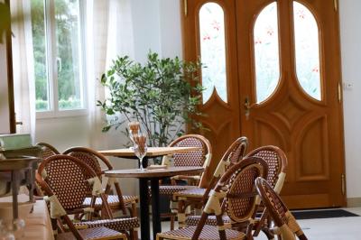 Salle de bain moderne avec douche à paroi vitrée, lavabo rond sur meuble en bois et miroir encadré en rotin.