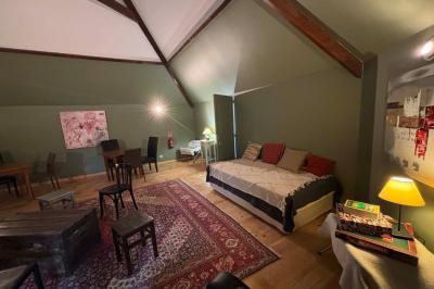 Salle de bain moderne avec douche à paroi vitrée, lavabo rond sur meuble en bois et miroir encadré en rotin.