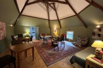 Salle de bain moderne avec douche à paroi vitrée, lavabo rond sur meuble en bois et miroir encadré en rotin.