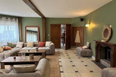 Salle de bain moderne avec douche à paroi vitrée, lavabo rond sur meuble en bois et miroir encadré en rotin.