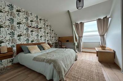 Salle de bain moderne avec douche à paroi vitrée, lavabo rond sur meuble en bois et miroir encadré en rotin.