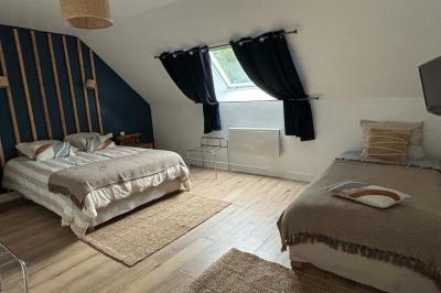 Salle de bain moderne avec douche à paroi vitrée, lavabo rond sur meuble en bois et miroir encadré en rotin.