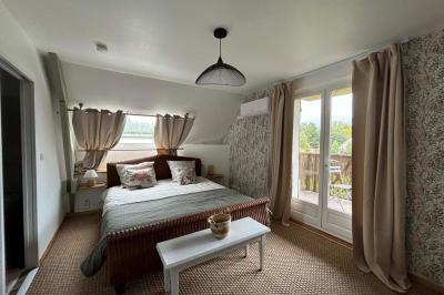 Salle de bain moderne avec douche à paroi vitrée, lavabo rond sur meuble en bois et miroir encadré en rotin.