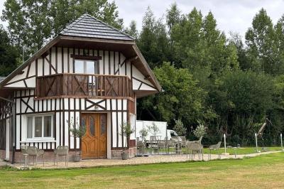 Salle de bain moderne avec douche à paroi vitrée, lavabo rond sur meuble en bois et miroir encadré en rotin.