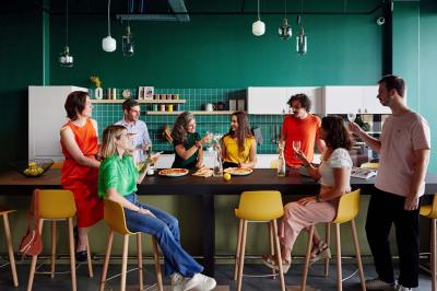 Chambre d'hôtel avec lit double, salle de bain attenante à carreaux rouges et décoration murale colorée.