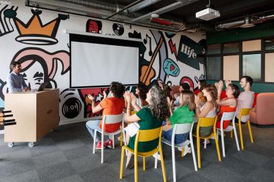 Chambre d'hôtel avec lit double, salle de bain attenante à carreaux rouges et décoration murale colorée.