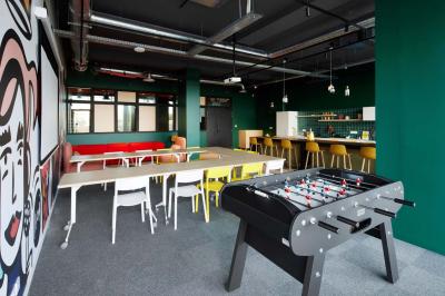 Chambre d'hôtel avec lit double, salle de bain attenante à carreaux rouges et décoration murale colorée.