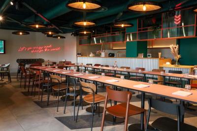 Chambre d'hôtel avec lit double, salle de bain attenante à carreaux rouges et décoration murale colorée.