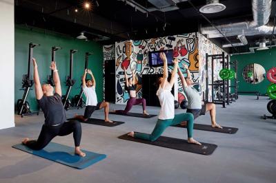 Chambre d'hôtel avec lit double, salle de bain attenante à carreaux rouges et décoration murale colorée.