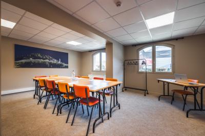 Un groupe de musiciens joue sur scène devant un écran affichant le logo et le slogan ’Base Camp Lodge’.