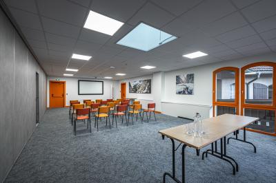 Un groupe de musiciens joue sur scène devant un écran affichant le logo et le slogan ’Base Camp Lodge’.