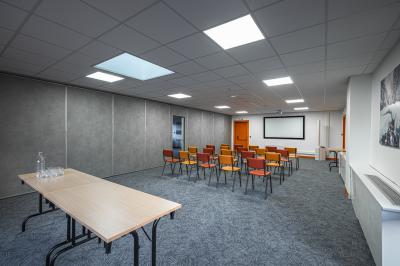 Un groupe de musiciens joue sur scène devant un écran affichant le logo et le slogan ’Base Camp Lodge’.