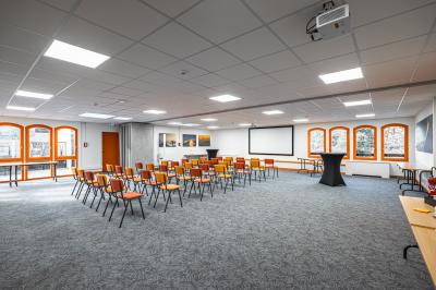 Un groupe de musiciens joue sur scène devant un écran affichant le logo et le slogan ’Base Camp Lodge’.