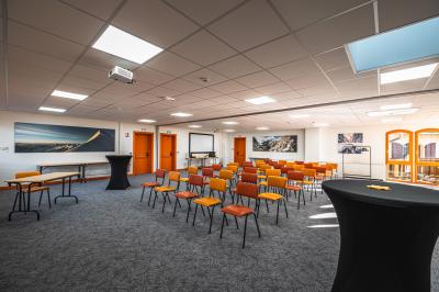 Un groupe de musiciens joue sur scène devant un écran affichant le logo et le slogan ’Base Camp Lodge’.