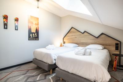 Un groupe de musiciens joue sur scène devant un écran affichant le logo et le slogan ’Base Camp Lodge’.